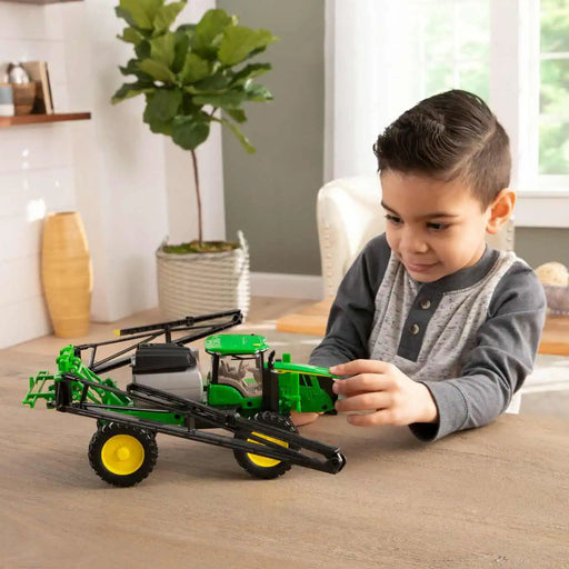 boy playing with the John Deere 1:32 412R Sprayer