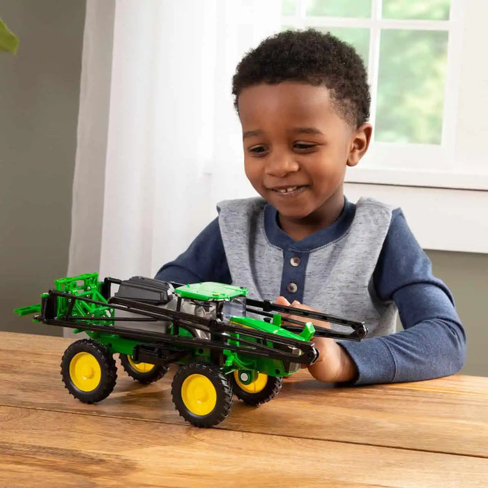 young boy playing with the John Deere 1:32 412R Sprayer