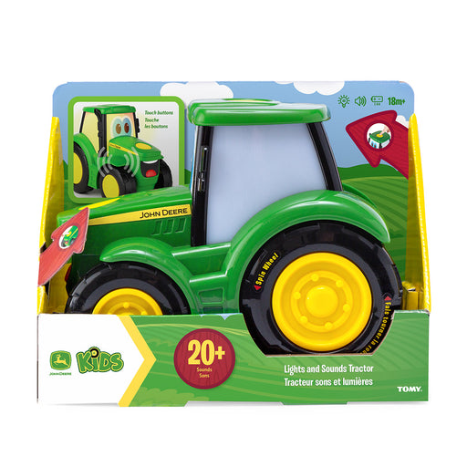 John Deere Lights N Sound Johnny Tractor in retail packaging, featuring a green body with yellow wheels and a light-up window, shown on a white background.