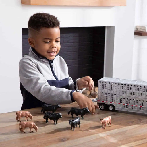 boy playing with the John Deere 1:32 Semi with Livestock Trailer Set