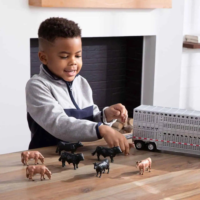 boy playing with the John Deere 1:32 Semi with Livestock Trailer Set
