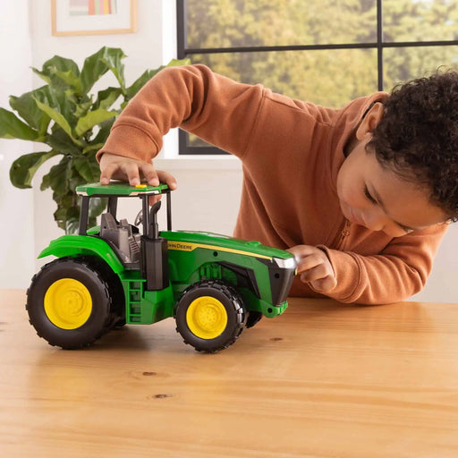 young boy playing with the John Deere Toy Tractor with Lights & Sounds