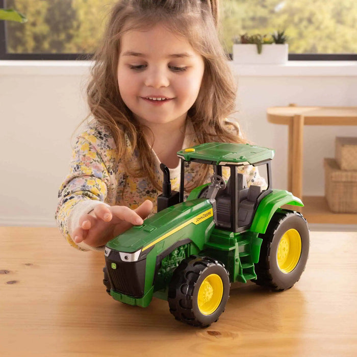 Young girl playing with the John Deere Toy Tractor with Lights & Sounds